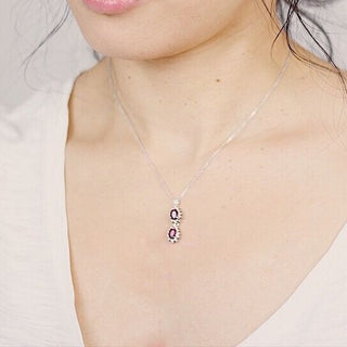 Silver pendant charm from JewelCreationsNY, featuring intricate designs, hanging on a delicate chain.