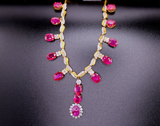 Ruby and diamond necklace by JewelCreationsNY featuring a delicate gold chain with a pendant of vibrant rubies and sparkling diamonds.